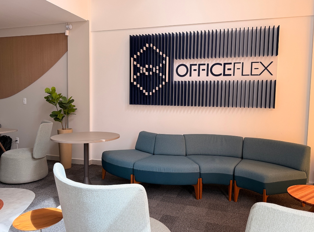 Showroom OfficeFlex com sofá azul modular e logo na parede
